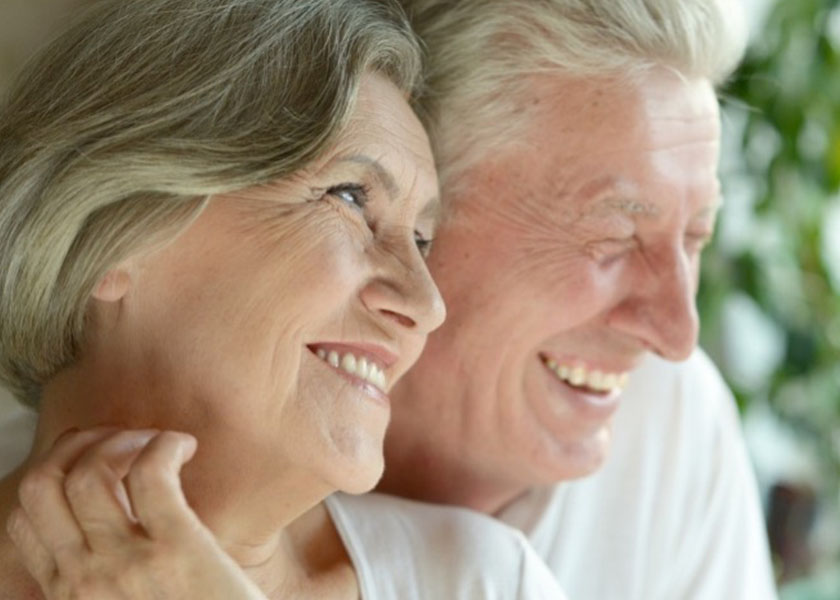 A close-up image of an older man and women smiling together